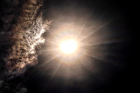 Solar Eclipse With Rays And Clouds